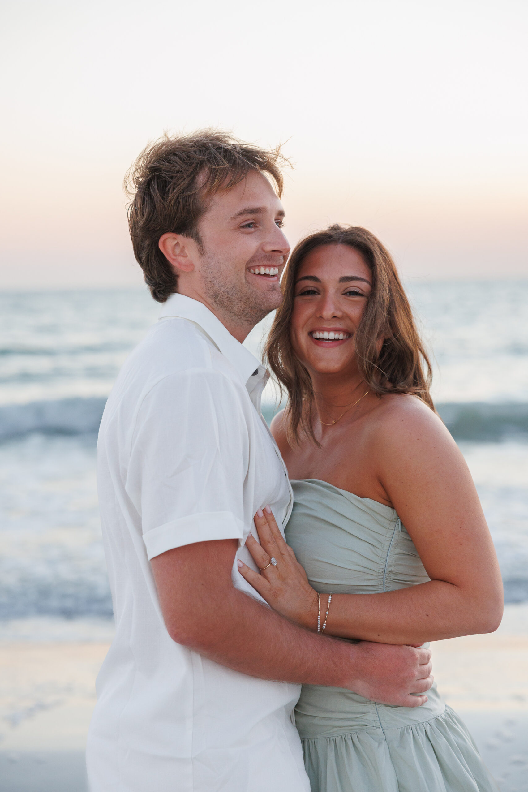 A close-up of two people in an intimate embrace, showcasing their arms and shoulders, with a soft focus background.